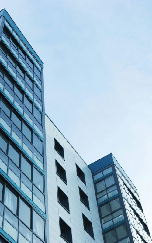 Low-angle view of a modern glass skyscraper against a clear sky in Poole, UK.